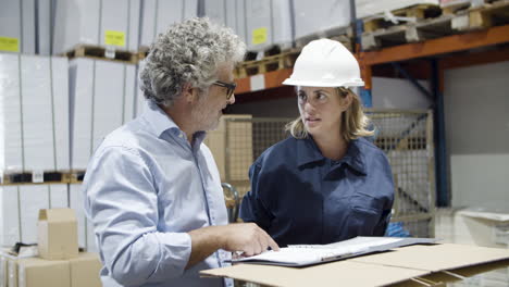 focused supervisor and female employee talking in warehouse