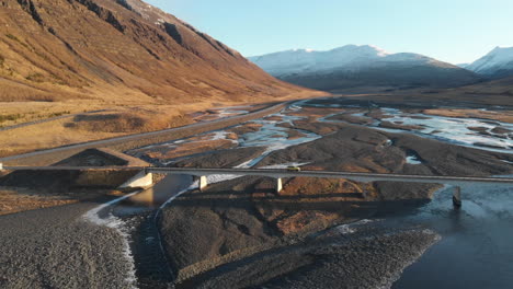 aerial view of car crossing the bridge over glacial river in icelandic highlands drone shot