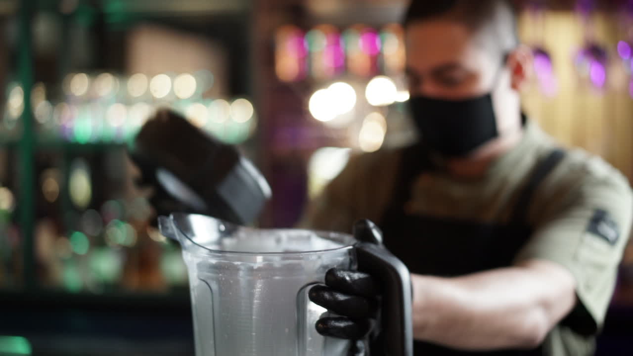 barista latino che serve cocktail dal frullatore piña colada margarita rallentatore