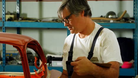 male mechanic writing on clipboard 4k