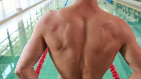 hombre en forma está listo para bucear en la piscina