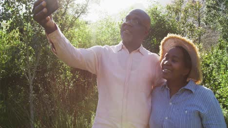 Glückliches-Afroamerikanisches-Seniorenpaar,-Das-Draußen-Ein-Selfie-Macht