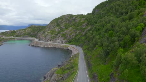 Old-camper-van-driving-on-the-scenic-route-of-Senja-Island-during-summer,-near-Hamn