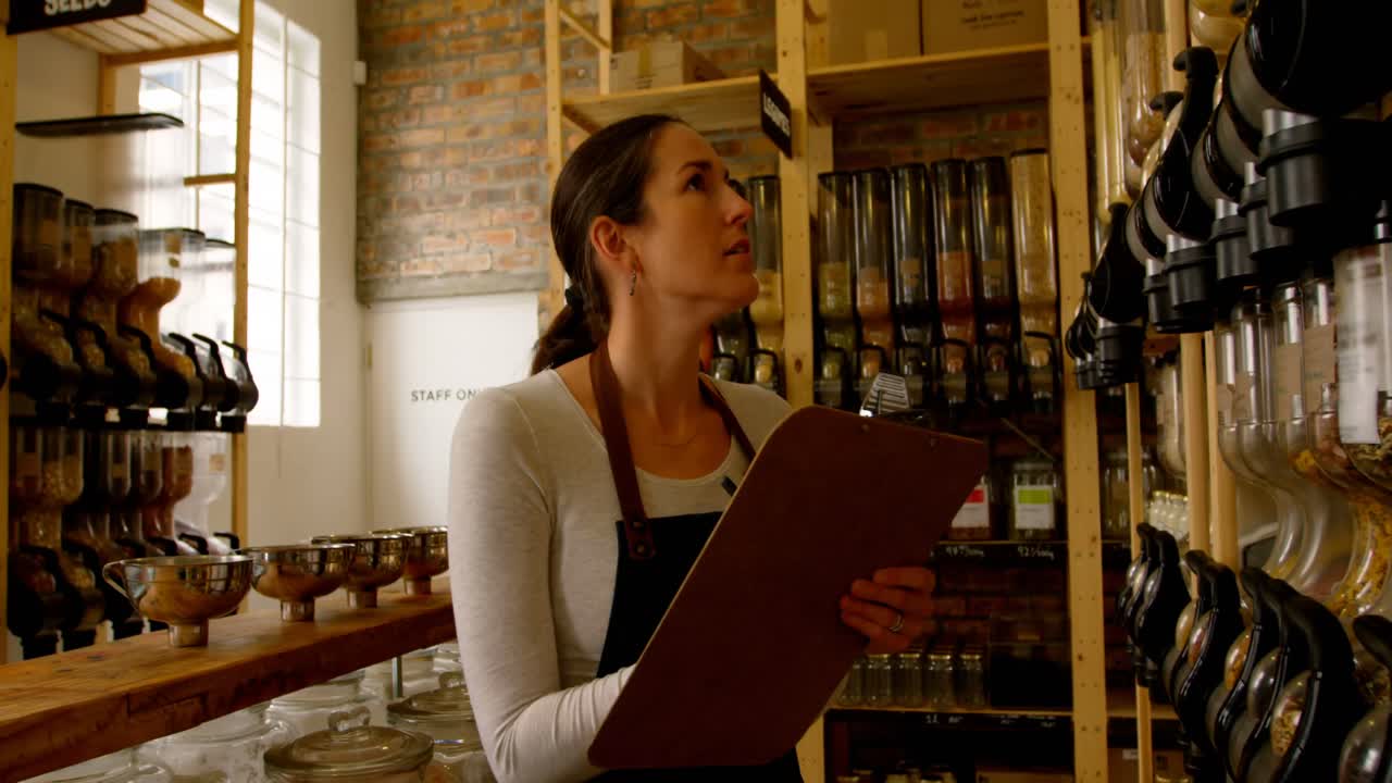 hermosas cosas femeninas comprobando las existencias en el supermercado 4k