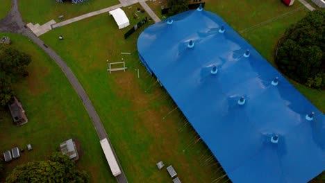 pan up revealing aerial shot of a empty music gig blue tent