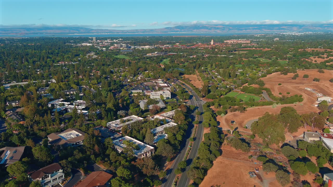 Drone trækker sig tilbage med opadgående tilt, der afslører venturekapitaldistriktet Sand Hill Road og det bredere Silicon Valley-landskab.