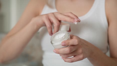 caucasian woman testing consistence of cream on her hand