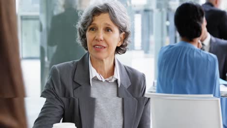 Mujer-De-Negocios-Interactuando-Mientras-Toma-Café