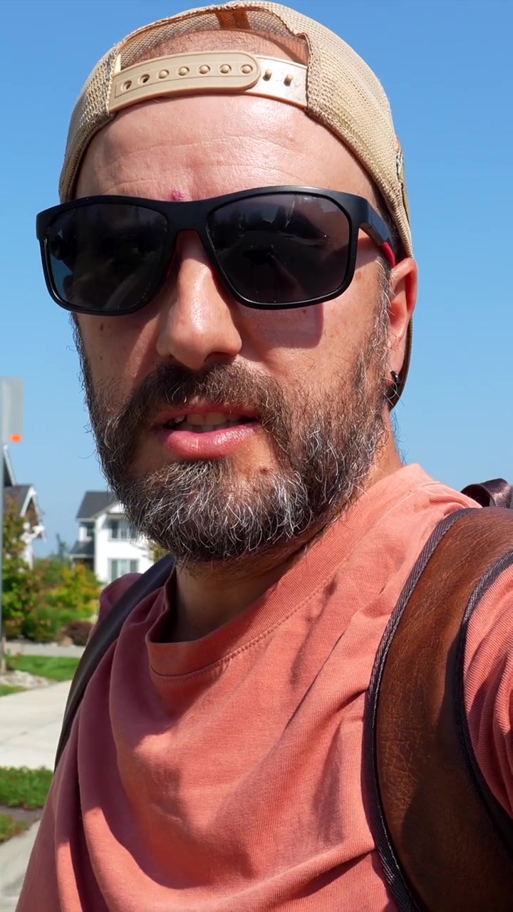 Uomo che passeggia in un quartiere residenziale in una giornata di sole