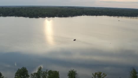 aerial, small personal fishing boat on a calm lake in the morning