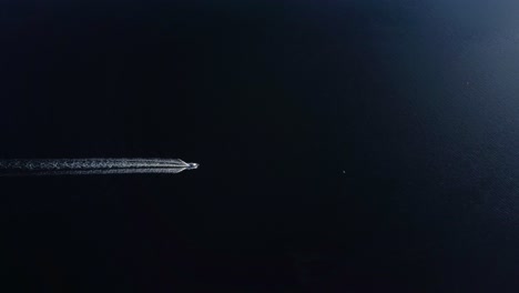 aerial view of a boat on a dark lake