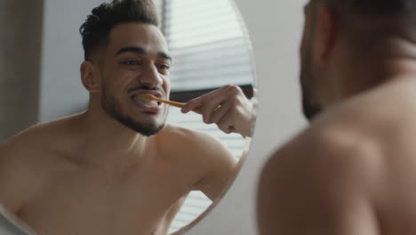 hombre cepillándose los dientes en el baño