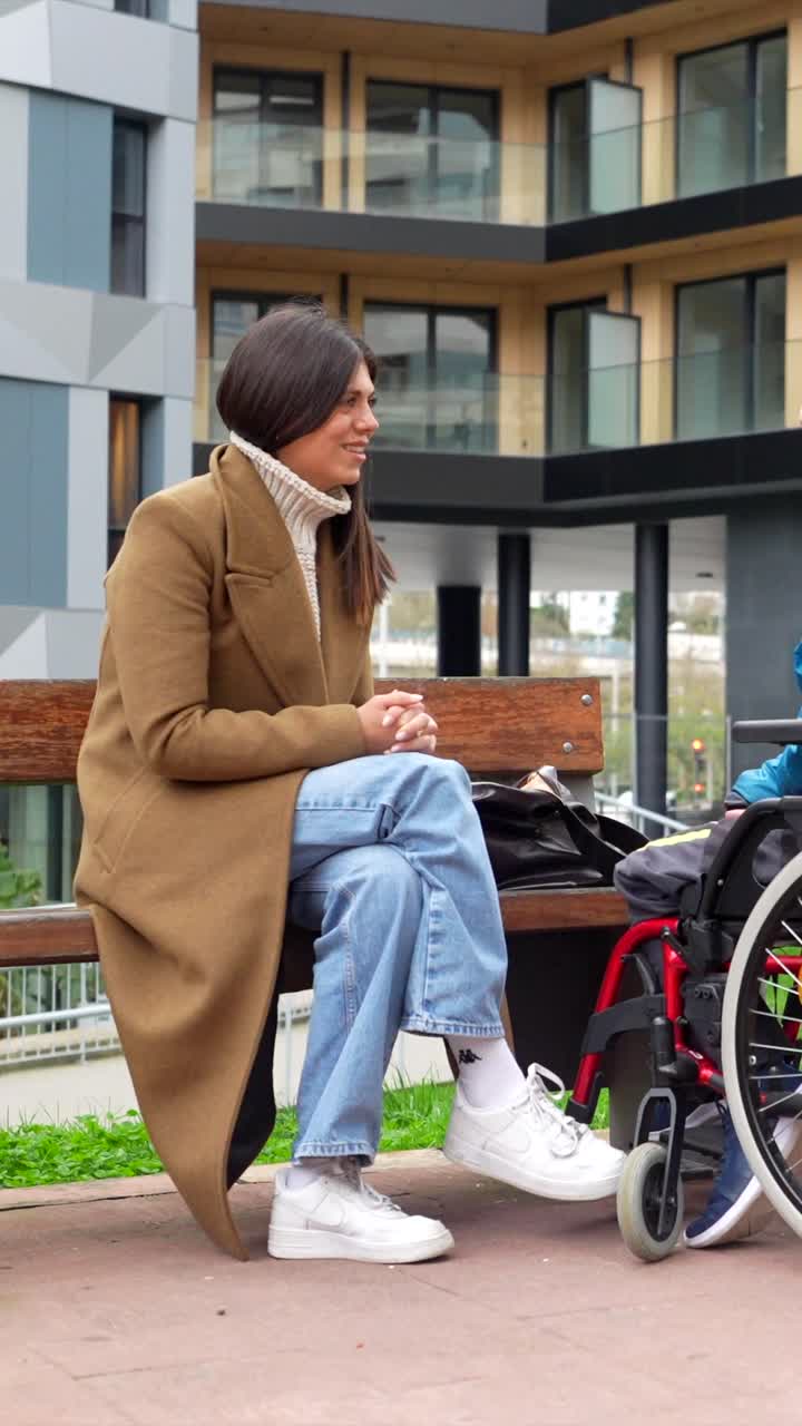 A Woman and a Man in a Wheelchair Having a Conversation Outdoors