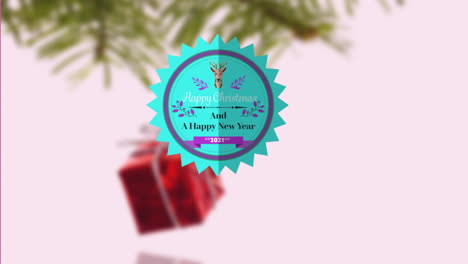 una decoración verde de navidad colgando de una rama sobre un fondo blanco.