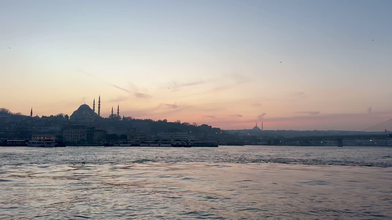 Stunning sunset over Galata Bridge, Istanbul, with mosque silhouette