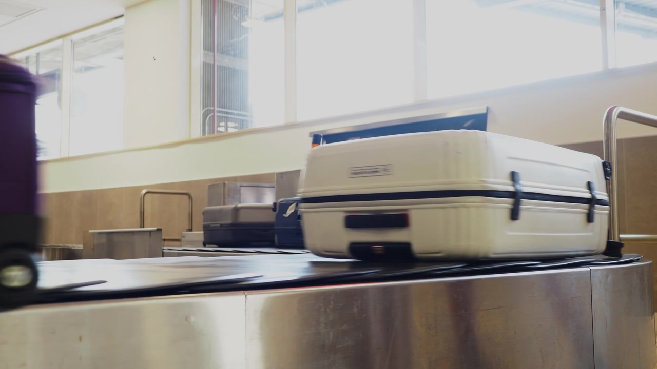 Suitcases Moving on Airport Baggage Claim Conveyor Belt