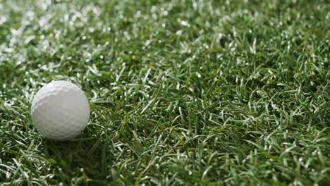 close up of golf ball on grass, copy space, slow motion