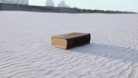 old-book-on-the-sand-beach