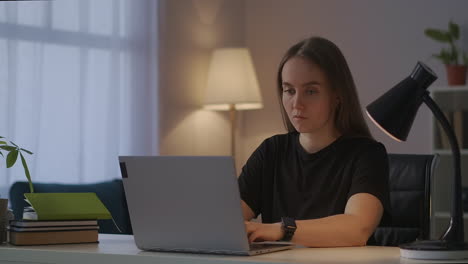 female-translator-is-working-from-home-typing-text-on-keyboard-of-laptop-freelance-and-part-time-job-at-evenings-portrait-of-woman-in-living-room