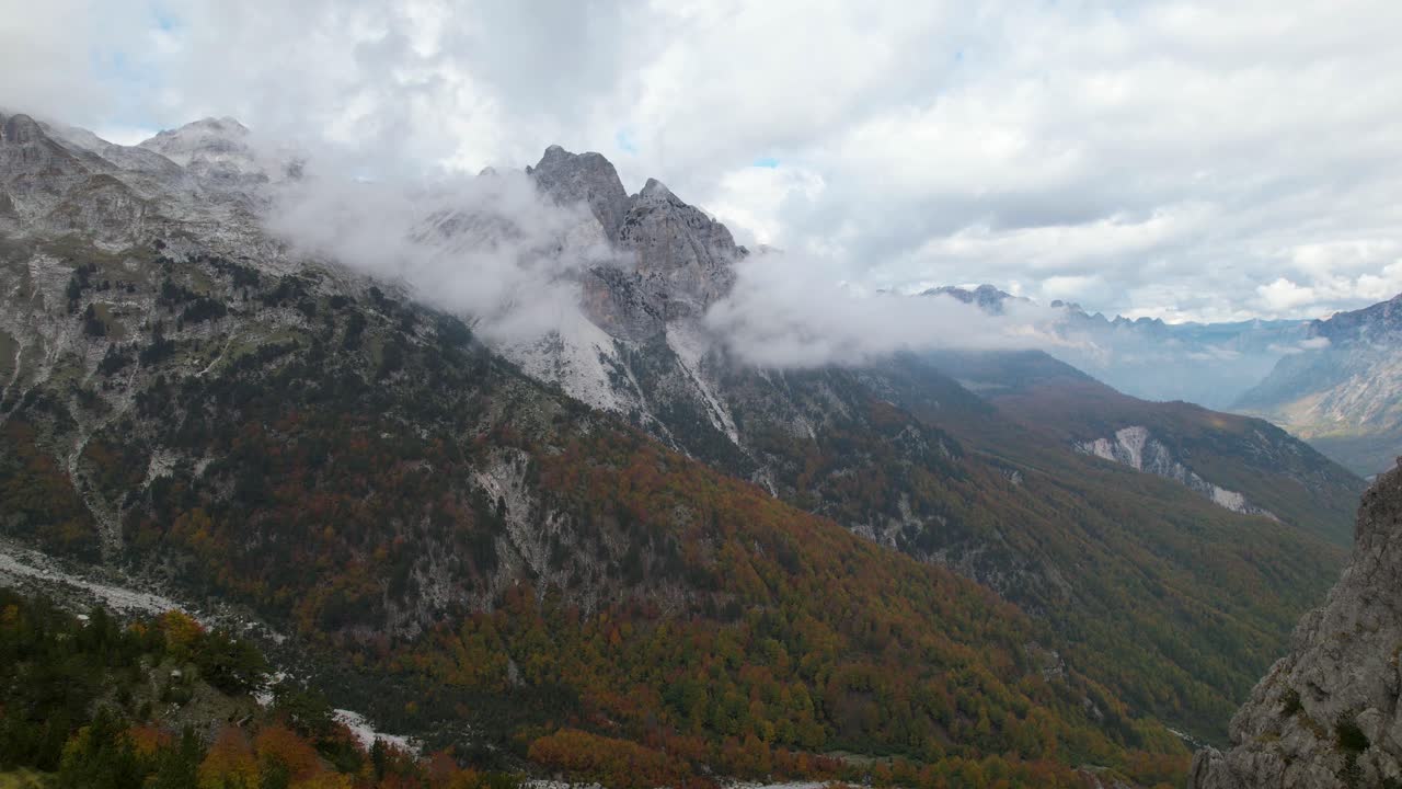 bosque salvaje y altas montañas en los alpes de albania en otoño con nubes y árboles dorados