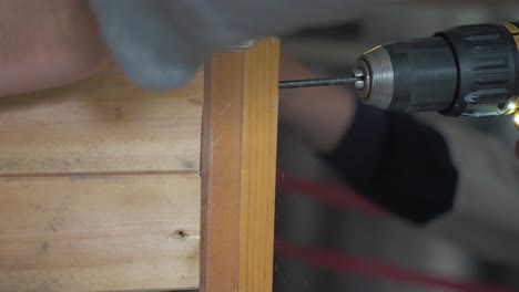 Drilling-into-wood-constructing-wooden-shelving