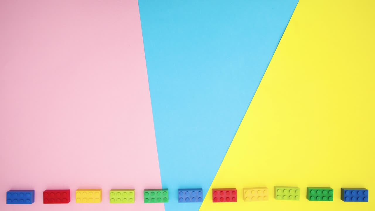 다채로운 벽돌이 다채로운 배경 아래에서 원으로 움직입니다. 어린이 장난감은 움직임을 멈니다.