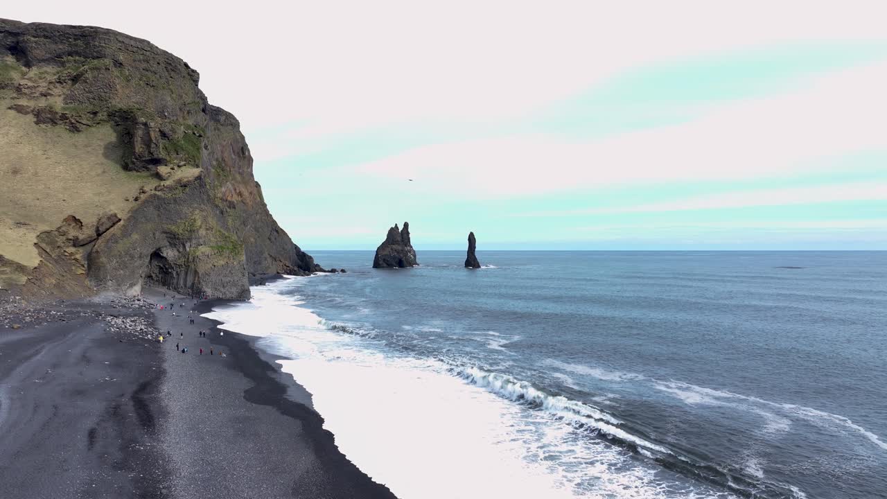 la impresionante altura de la montaña, la pendiente gradual de la playa, y el lienzo constantemente cambiante de nubes en el cielo, playa de arena negra