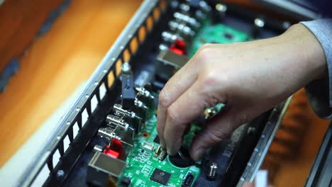 engineer installs capacitor on motherboard