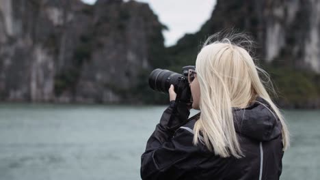 vista de mano de un turista con una cámara que fotografía un paisaje marino