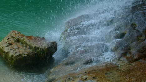 water falls from the grotto cliff down to the rocks below