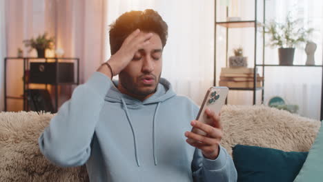 happy man using smartphone scrolls through news on smartphone reacting with surprise and excitement