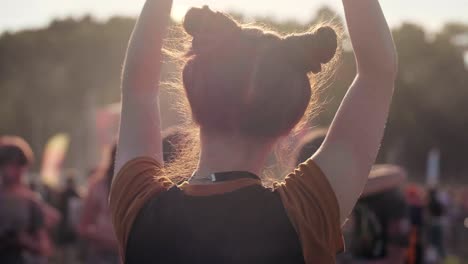 Rear-view-of-woman-dancing-among-bright-sunbeams