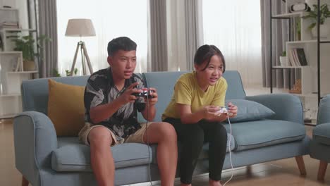 asian children with joystick game playing video games at home