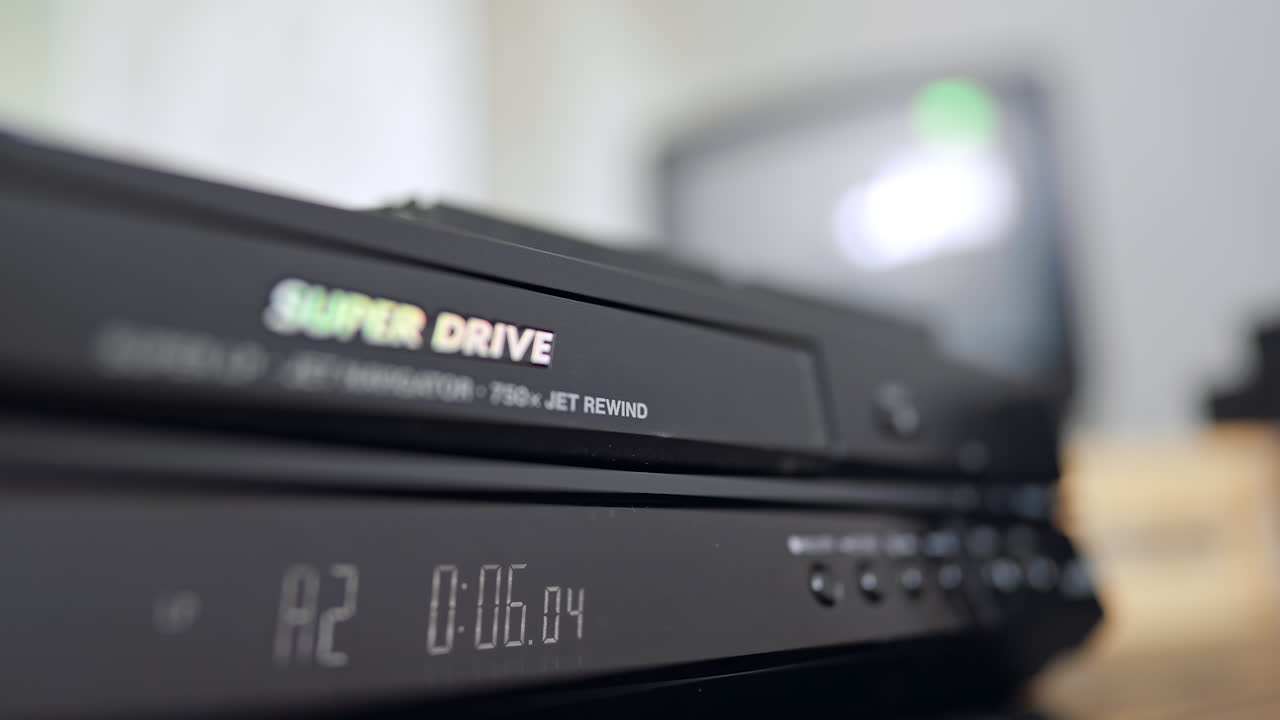 VHS tape appears from the recorder. Close up. Hand takes away the tape from the player