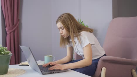 the young girl is angry at home. young girl working with laptop.