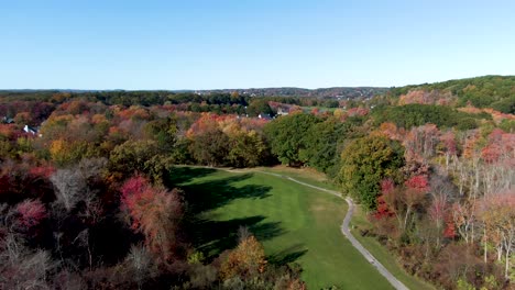 majestic autumn colors with small town of haverhill behind, drone descending view