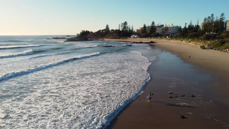 drone aerial pan shot of surfer walking on beach town rural coastal lifestyle tourism travel views port macquarie nsw mid north coast australia