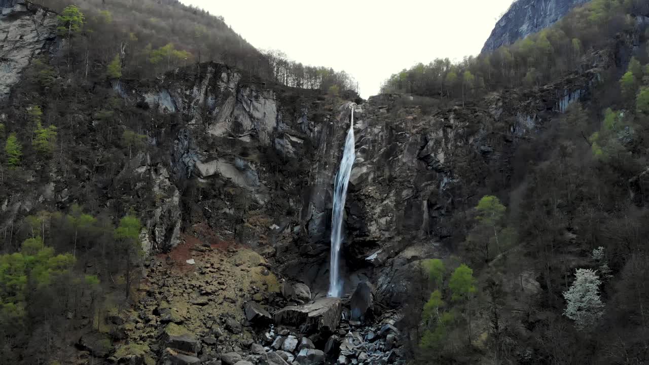 sobrevuelo aéreo sobre foroglio en ticino, suiza con un movimiento panorámico desde la cascada hasta los tejados de las antiguas casas de piedra en el atardecer del pueblo
