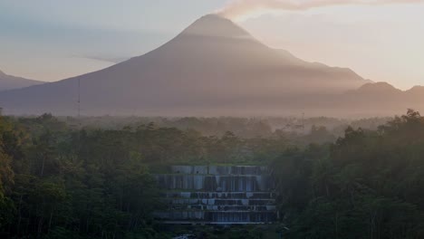 vista aérea de las cascadas grojogan watu purbo y el volcán merapi en la niebla
