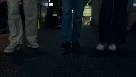 group of friends walking at night in a city street