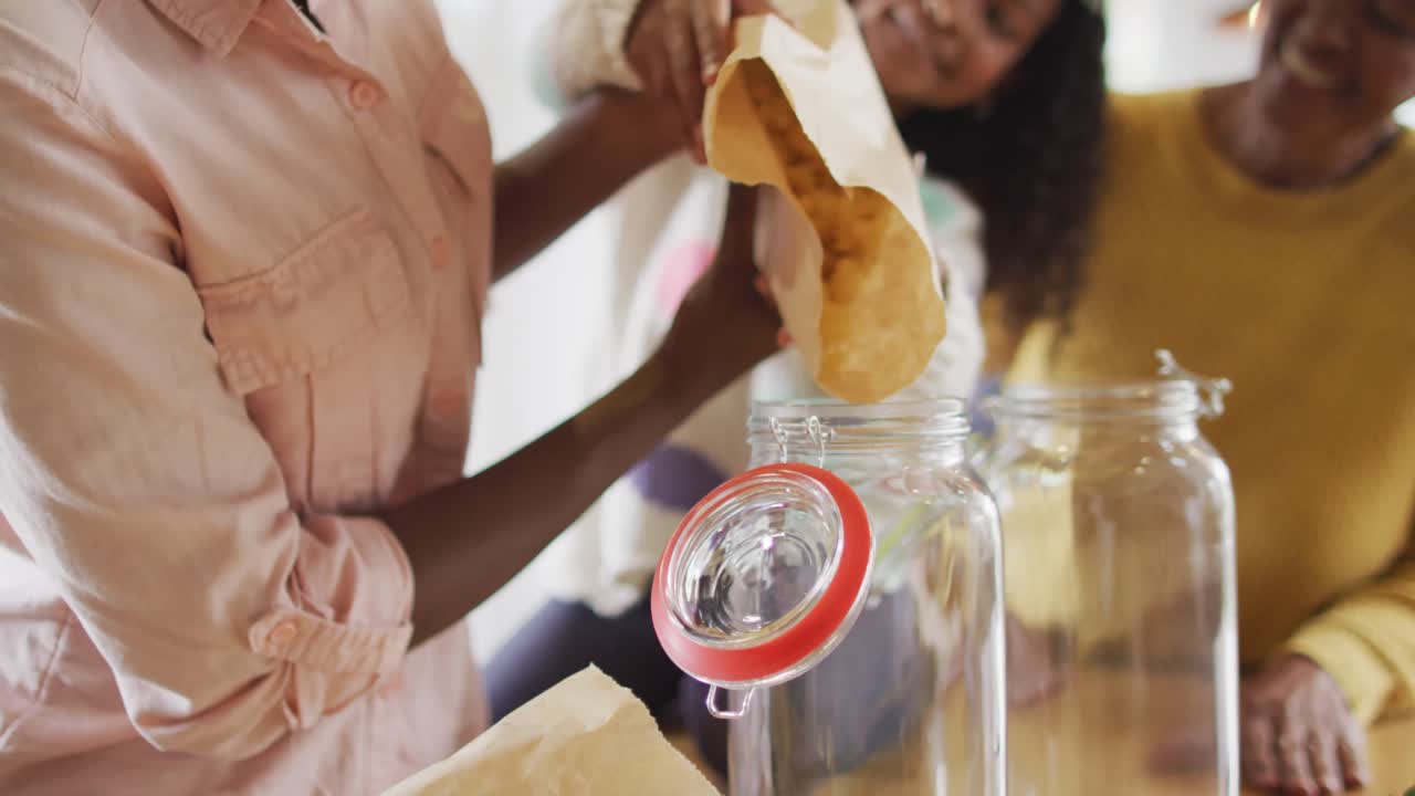 행복한 아프리카계 미국인 어머니와 딸이 할머니와 함께 음식 쇼핑을 풀고 있는 영상