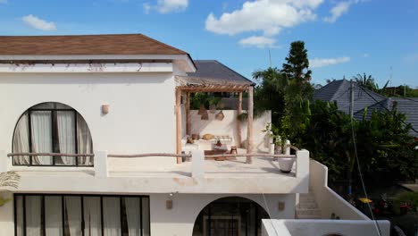 aerial zoom in of beautiful white villa bohemian balcony design in bali