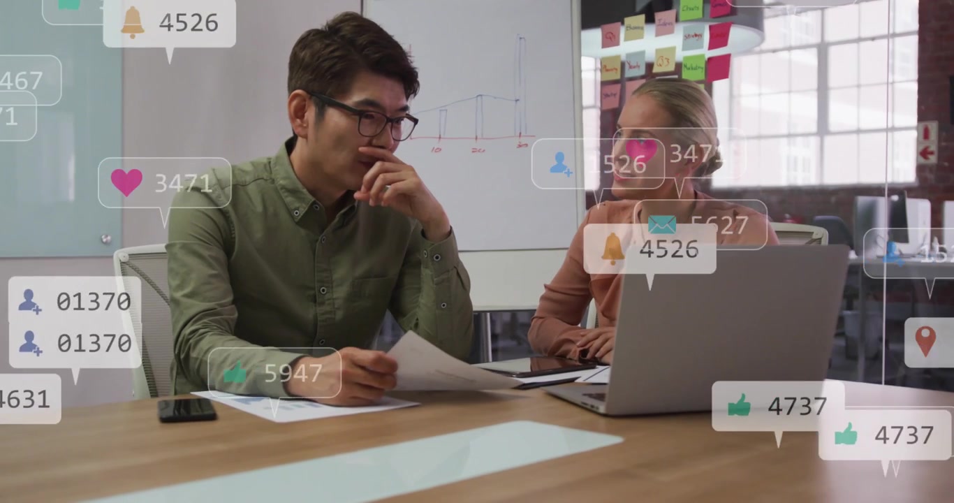 Analyzing colleagues in tops pointing at laptop and papers at table, overlays appearing for metrics
