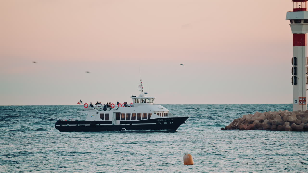 A ferry boat traveling across open water under a pastel sky