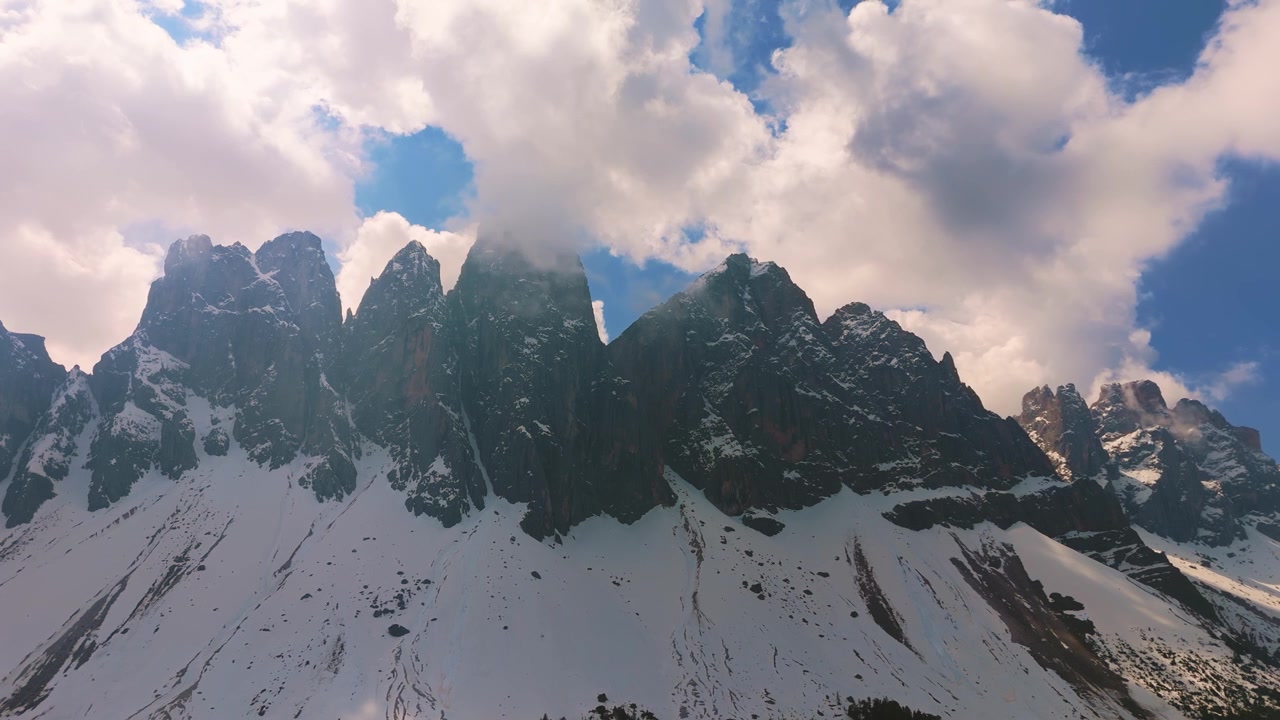 Cime Geisler innevate nel Parco Naturale Puez-Odle, catena montuosa delle Odle avvolta dalle nuvole. Veduta aerea delle Dolomiti.
