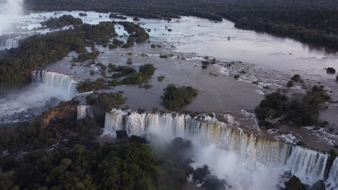 impresionante toma aérea de gigantescas cascadas de iguazú entre rocas durante el día soleado - brasil y argentina en américa del sur - lugar turístico con vista épica desde drones