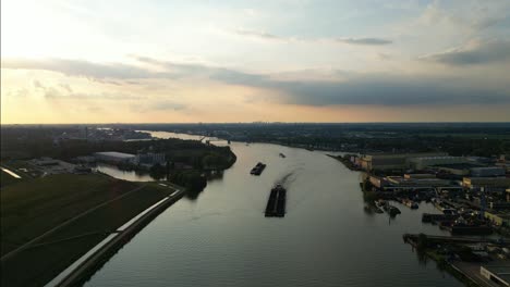 aerial view of powerful ship pushing four barges on river along industrial zone