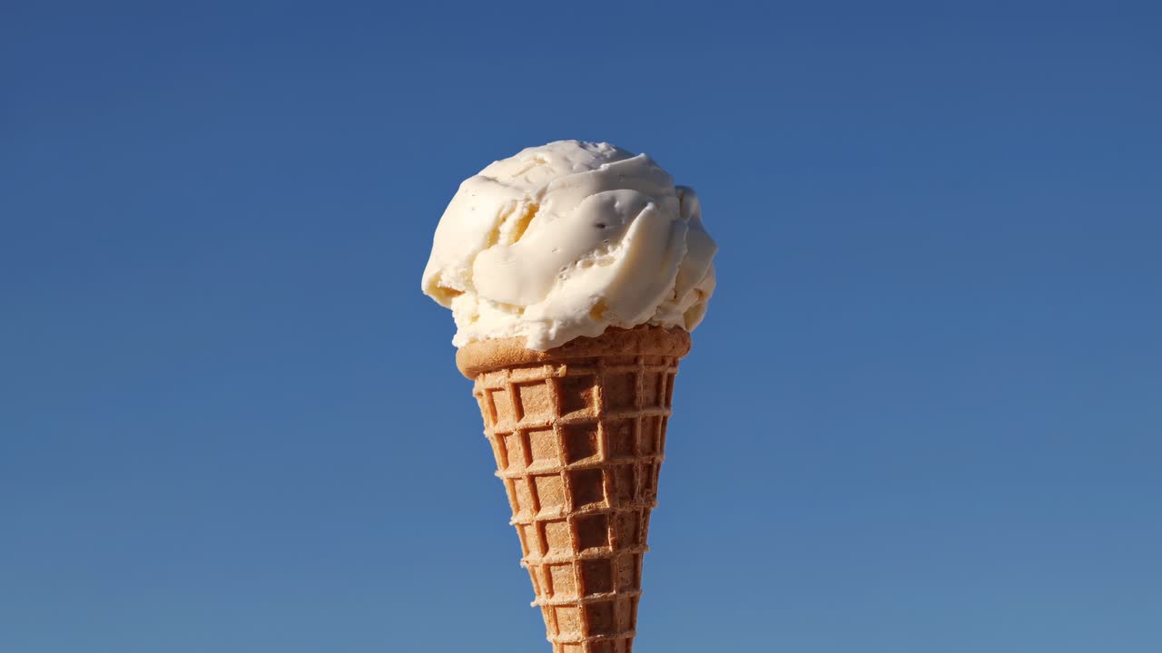 Smeltend bolletje vanille-ijs in een wafelhoorntje