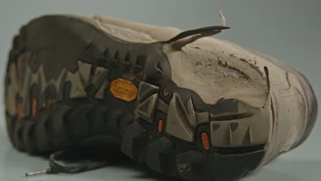 zoom out of torn heel of rubber sole of hiking shoe