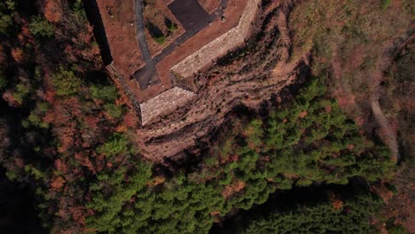 aerial drone fly above rusty stone indigenous land ruins in takeda castle japan